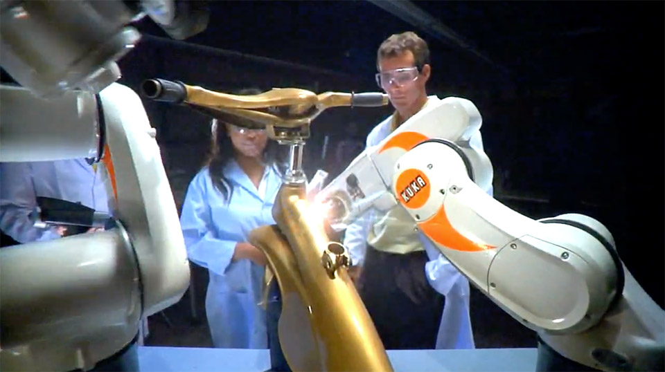 Students working on a tricycle using Kuka robots in a scene from the Georgia Tech 2009 PSA
